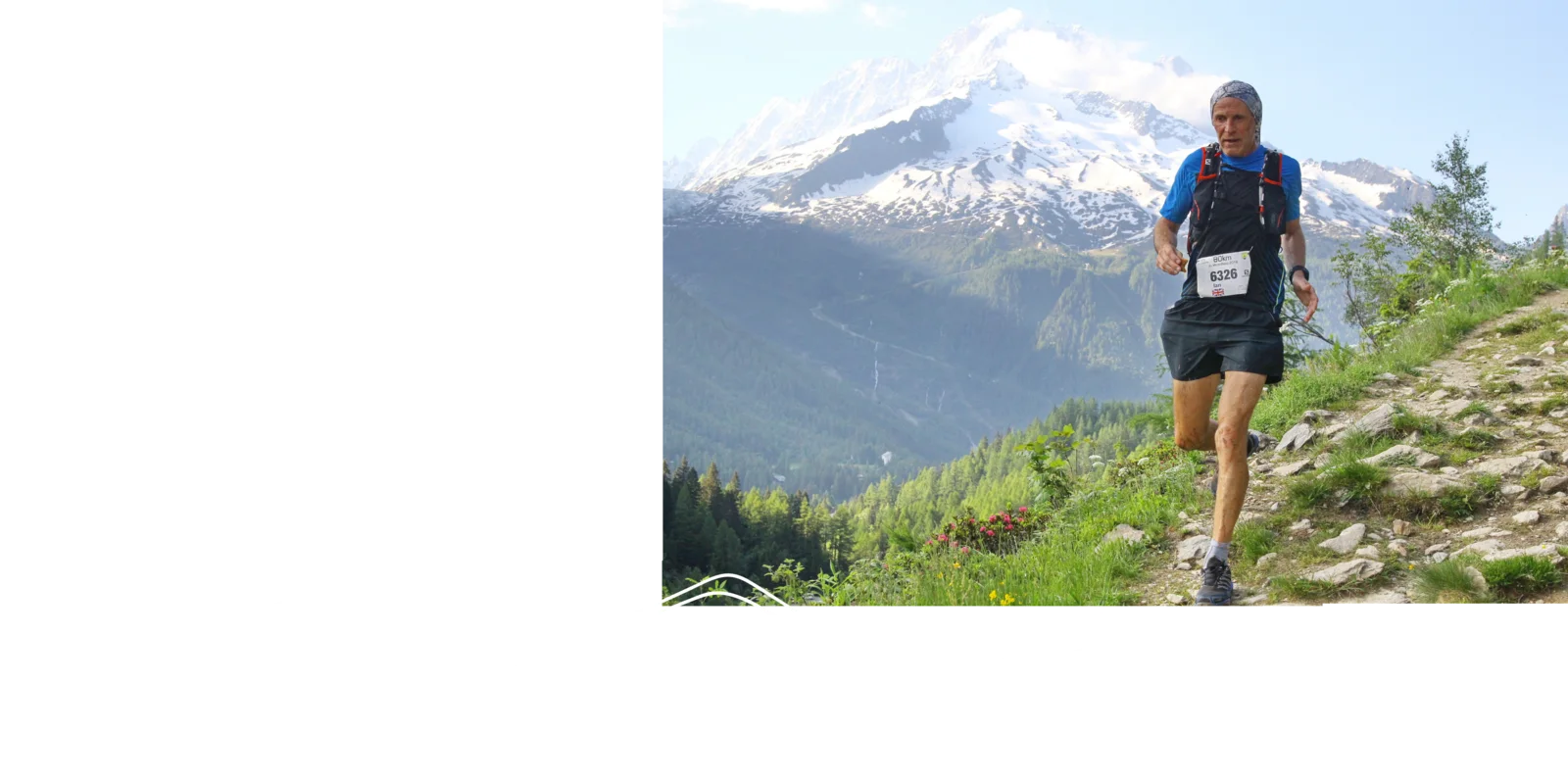 Ian running a mountain trail below a snow-capped peak