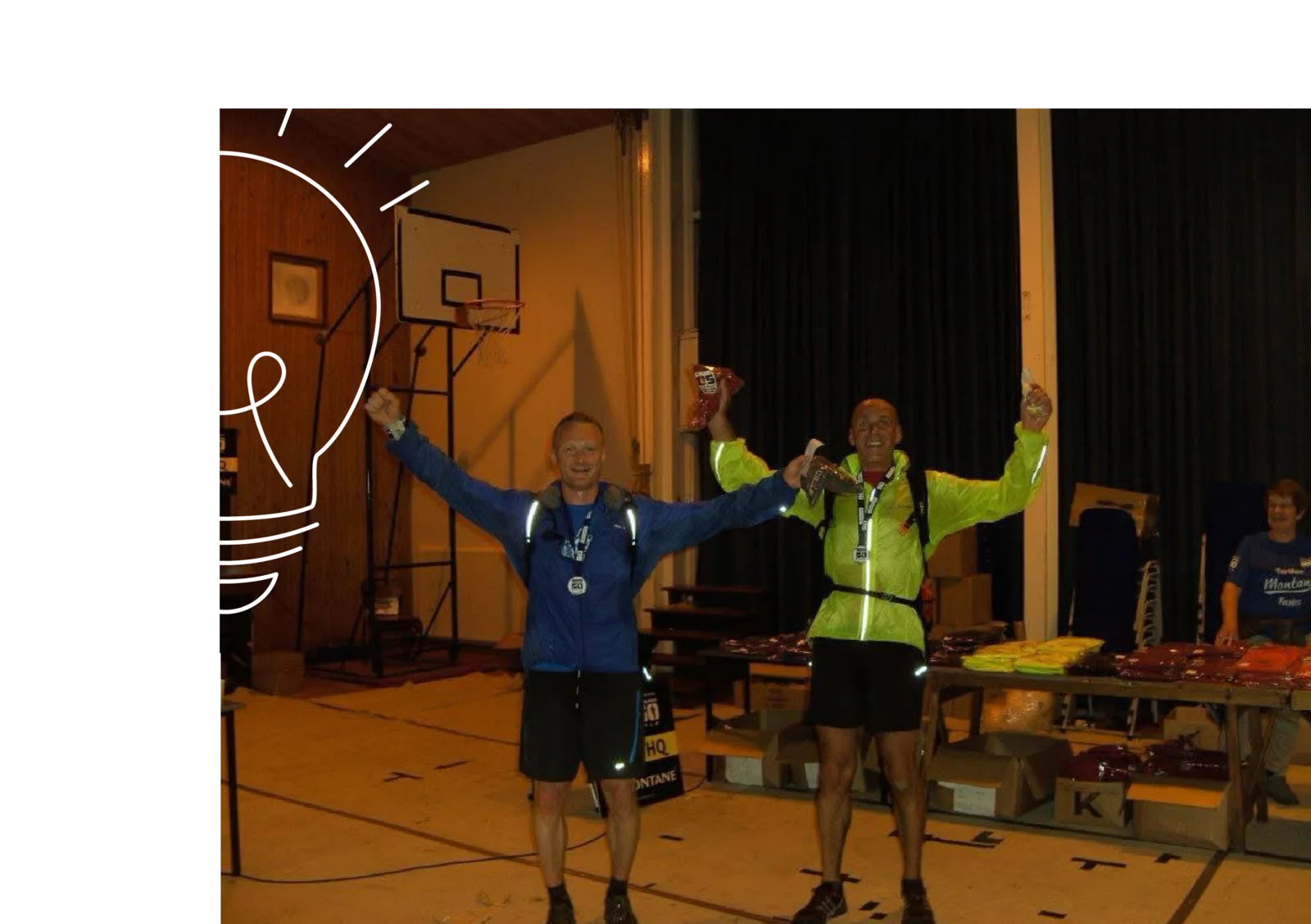 Two runners celebrating with arms raised at an event finish